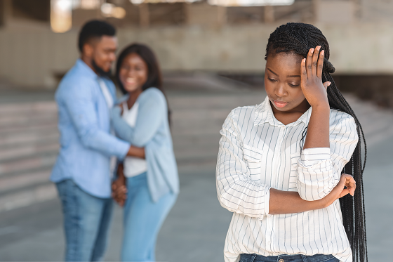 stressed woman in foreground and happy couple in background