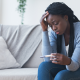 sad woman staring at a pregnancy test