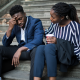 woman and stressed man sitting on stairs