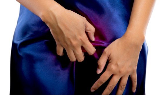 Woman scratching her vaginal area through her nightgown