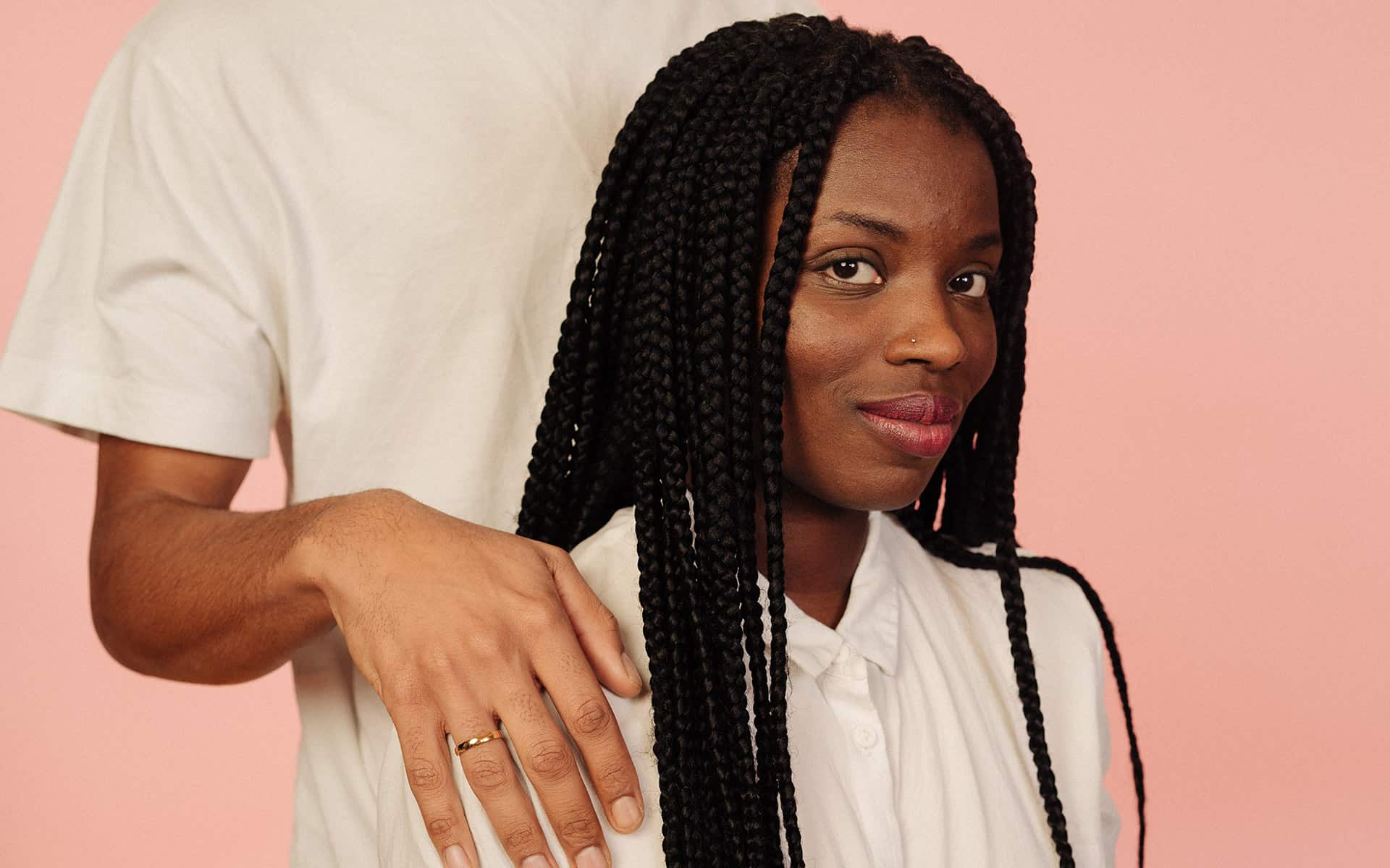Woman with partner's hand on her shoulder
