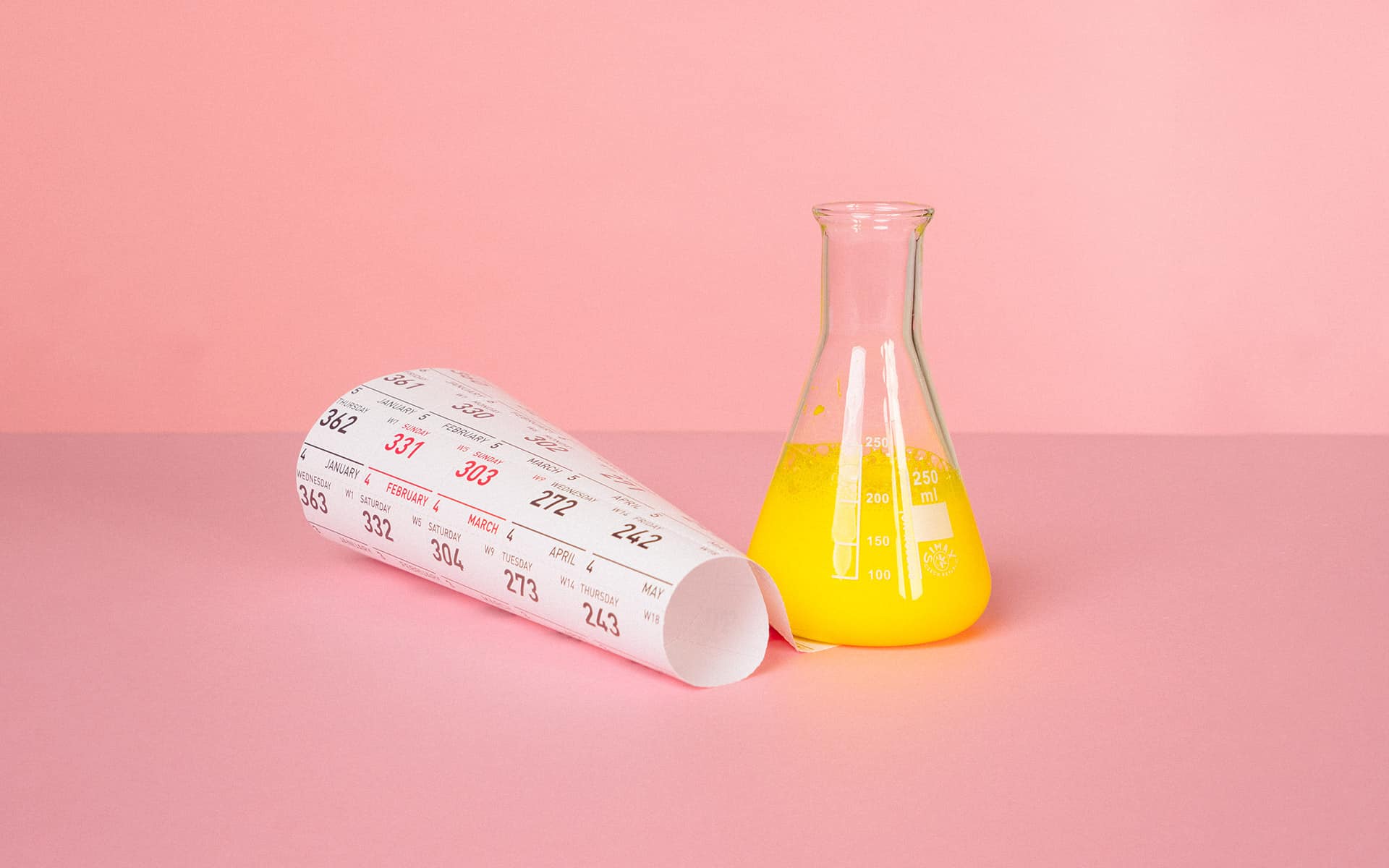 Calendar and beeker with yellow fluid