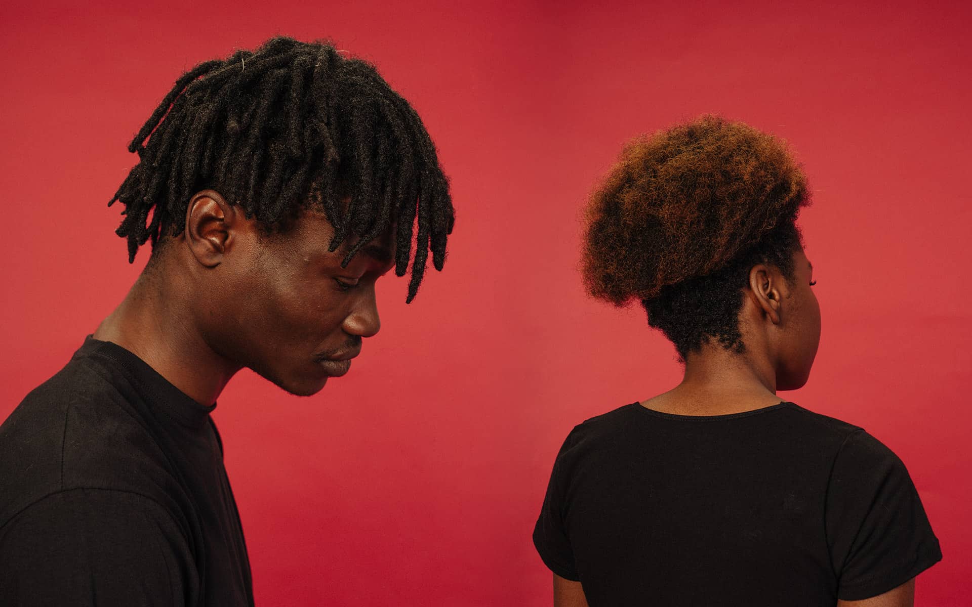Two people, one turned away, one with his head hanging low