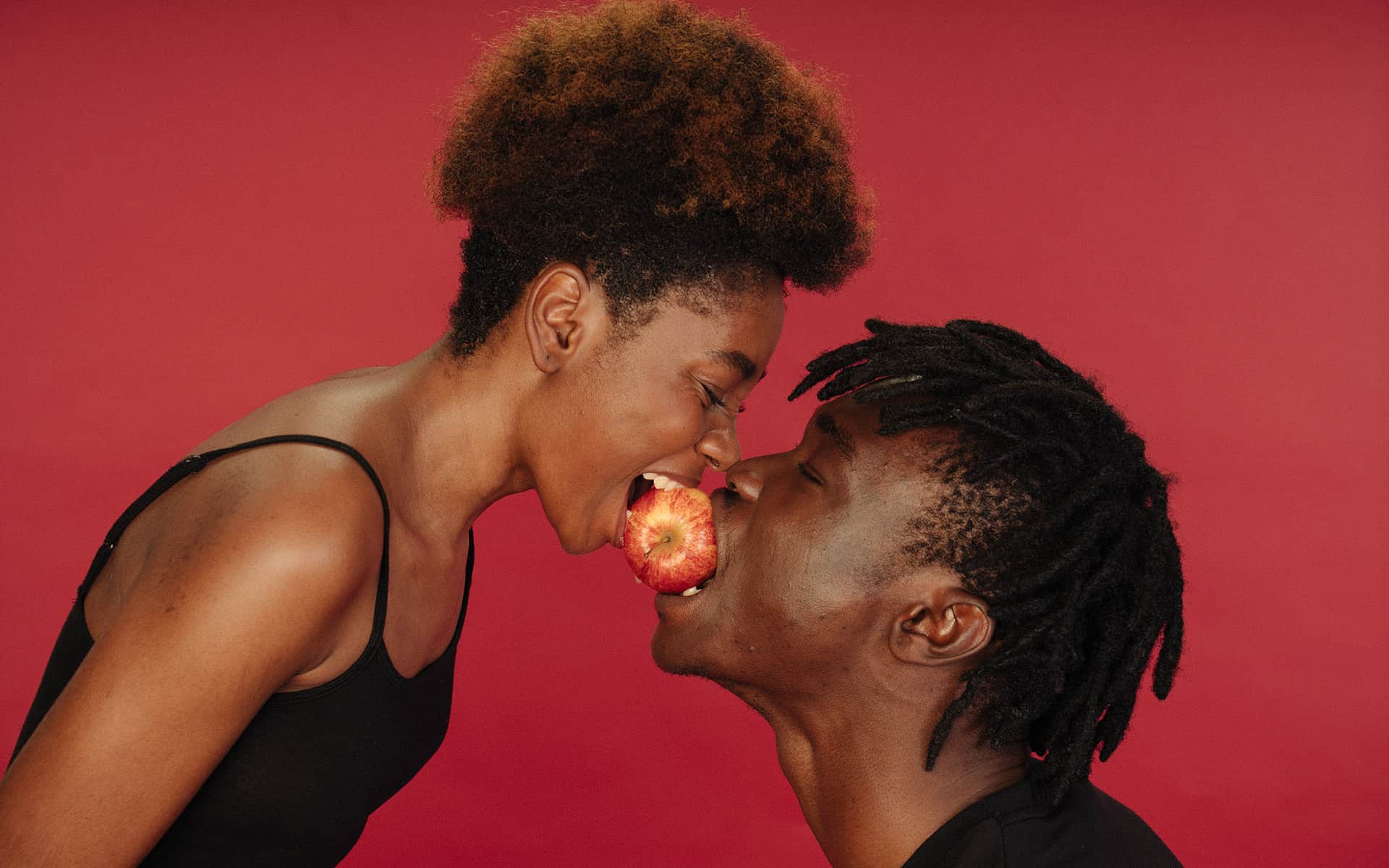 Couple having fun with an apple