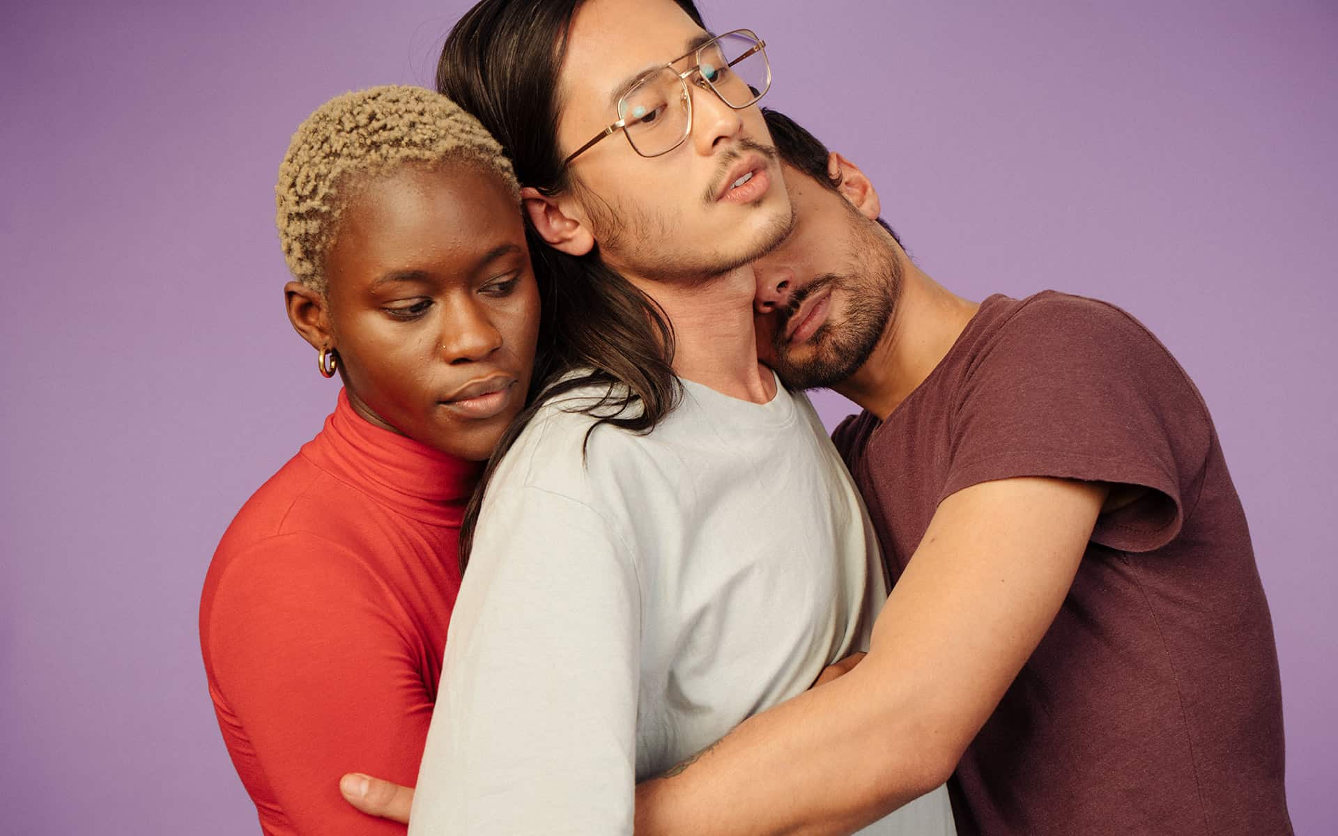 People of various genders embracing each other