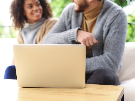 Playful couple in front of laptop