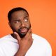 black man look empty space while holding chin