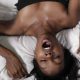 woman laying back on her back with mouth wide open