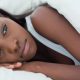 sad woman lying in bed