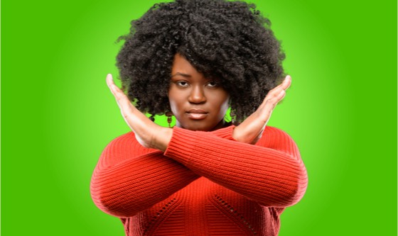 Beautiful african woman annoyed making stop sign crossing hands, saying no, expressing security, defense or restriction