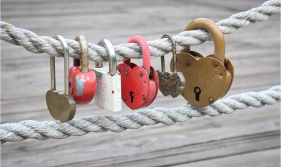 Heart-shaped padlocks suspended from a hemp rope