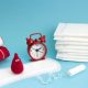 a stack of pads with white packaging and a red clock