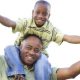 Boy carried by dad on neck and shoulders