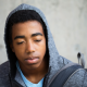 young man wearing grey hoodie looking stressed