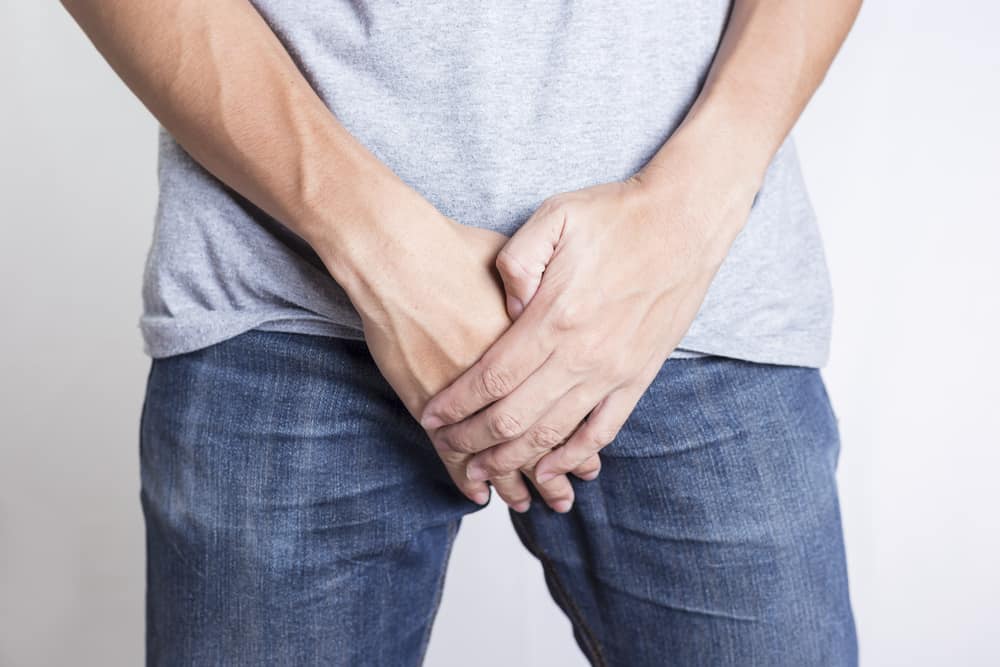 white male holds crotch