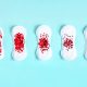 Menstrual pad with red glitter on blue colored background
