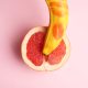 A ripe banana resting on half an orange