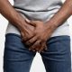 man holding crotch area with both hands